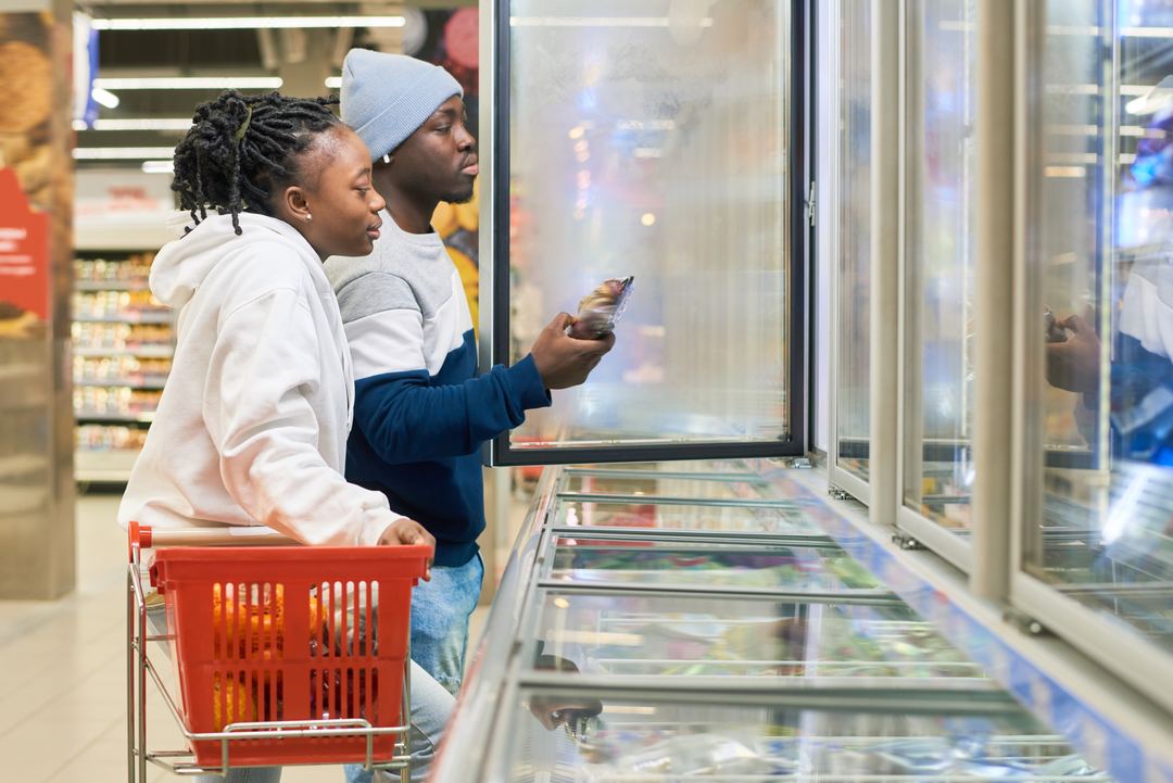 Two shoppers looking into a supermarket freezer